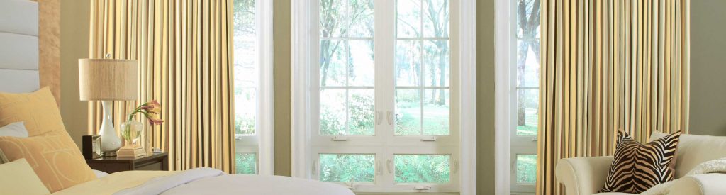 Shows motorised curtains in bedroom, with woodland scene outside window.